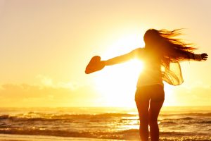 Silhouette of a woman dancing by the ocean